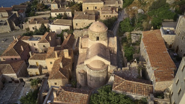 Drone view, aerial view of a compact church structure with domed roof, surrounded by traditional