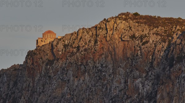 Orhodox church of Hagia Sophia, chapel on bright rock wall in evening light with scenic backdrop,