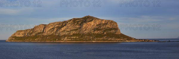 Rocky island in calm water at sunset with blue sky, Monemvasia, Monemvassia, Malvasy, Byzantine
