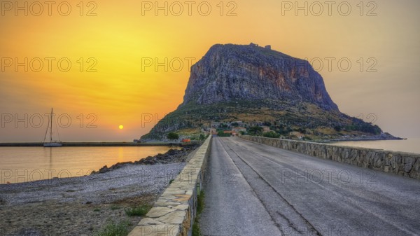 HDR road leads to an imposing mountain by the sea in the soft light of sunrise, Monemvasia,