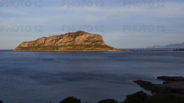 Flat rocky island in the calm blue sea under a clear sky, Monemvasia, Monemvassia, Malvasy,