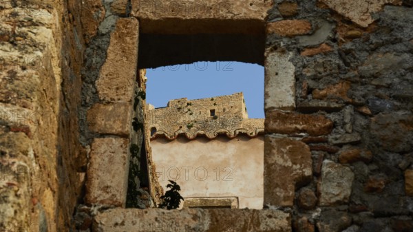 Soft morning light, view through an old window of a ruin with clear blue sky, Monemvasia,