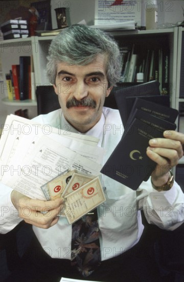 Berlin, DEU, 10.11.1998 -- portrait of Diyap Sarkalli holding Turkish passports and other documents