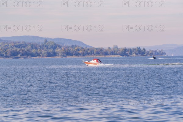 Two motorboats race across the water surface of a lake in a vast landscape, boat trip, Lake