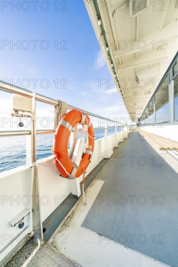 Side view from a ship deck with lifebuoy, calm sea and sunny sky, boat trip, Lake Constance,