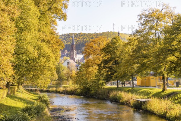 Autumn river landscape with a church and colorful trees in the background, Nagold, Black Forest,
