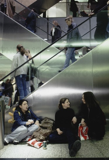 Berlin, DEU, 12.09.1999 -- Young visitors to the Potsdamer Platz arcades take a cigarette break.