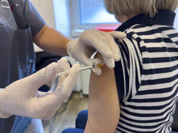 Patient woman receives injection in upper arm for vaccination against contagious disease flu flu