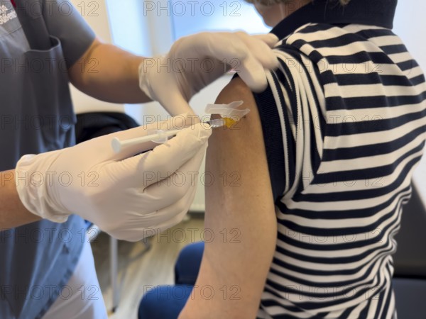 Patient woman receives injection in upper arm for vaccination against contagious disease flu flu