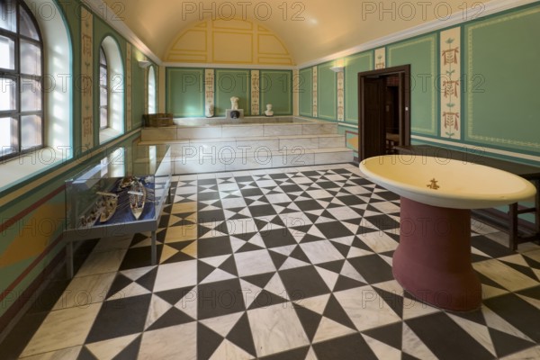 Reconstructed Roman ancient caldarium hot bath heating room with hot water pool in the background