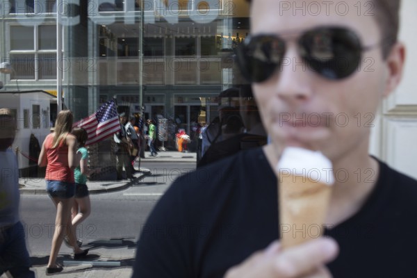 DEU Germany Germany Berlin tourist with ice cream at Checkpoint Charlie