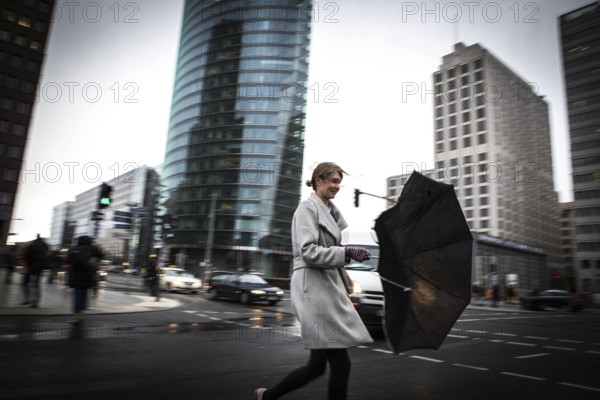 DEU Germany Germany Berlin Woman fighting against the wind at Potsdamer Platz