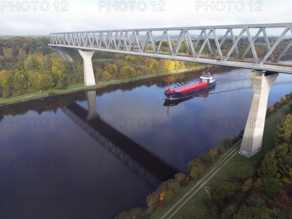 Cargo ship sails under the Grünental High Bridge in autumn through the Kiel Canal, NOK, Kiel Canal,