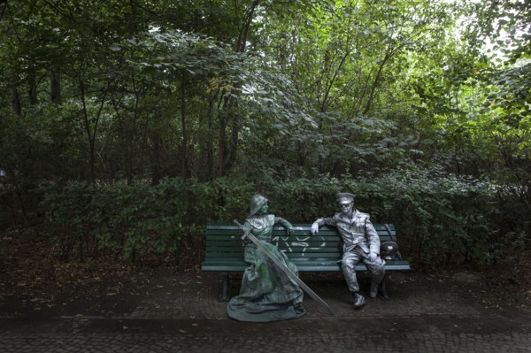 DEU Germany Germany Berlin Two performers take a break on a bench between the Reichstag and the