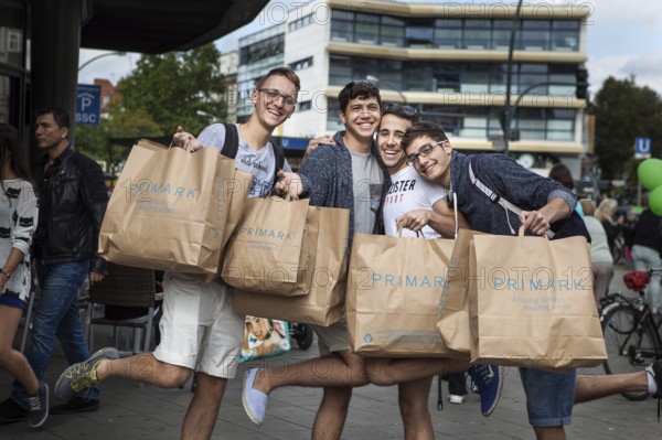 DEU Germany Germany Berlin Young Italian tourists pose with their Primark bags on Schlossstraße in