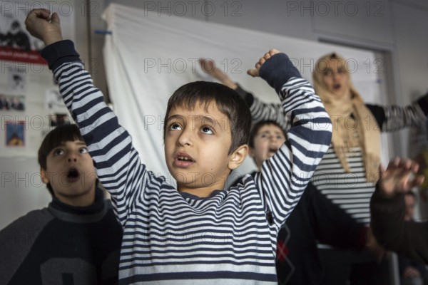 DEU Germany Germany Berlin An animation team entertains refugee children in an asylum center in