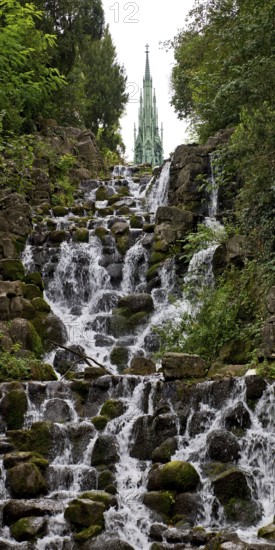 Artificial waterfall in Victoria Park, with the national monument on Kreuzberg in the background,