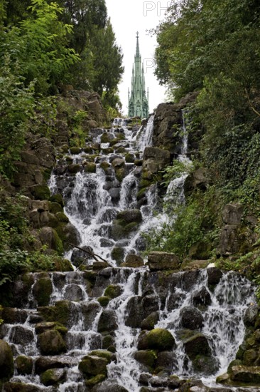 Artificial waterfall in Victoria Park, with the national monument on Kreuzberg in the background,