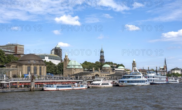 Elbe and boats at the St. Pauli piers, historic building with a level tower, in the back church