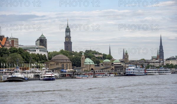 Elbe and boats at the St. Pauli piers, historic building with a level tower, in the back church