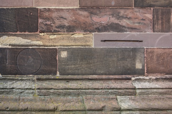 Historic engravings on a stone wall at the Freiburg Minster in Freiburg im Breisgau, a city in