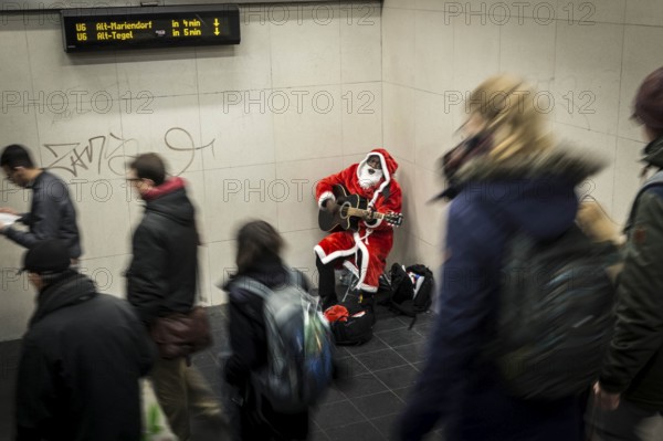 DEU Germany Germany Berlin A dark-skinned singer dressed as Father Christmas plays the guitar in
