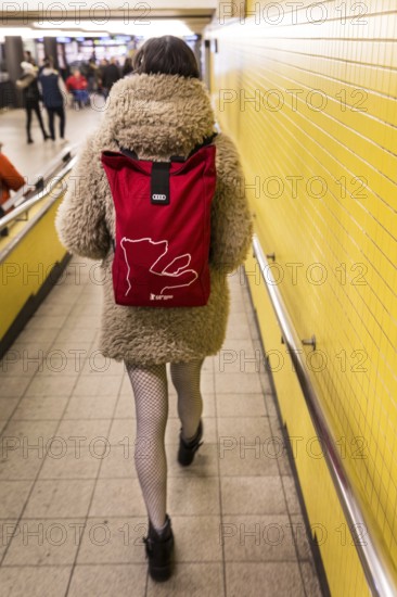 DEU Germany Germany Berlin A woman wears a Berlinale backpack with a plush coat and fishnet