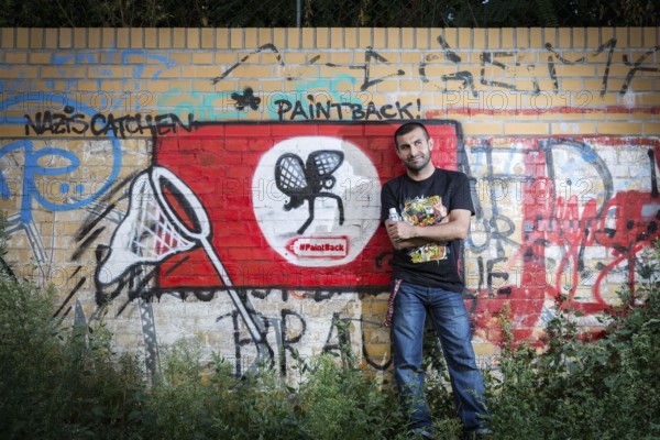 Germany Germany DEU Berlin Graffiti artist Ibo Omari in front of one of his works on a playground