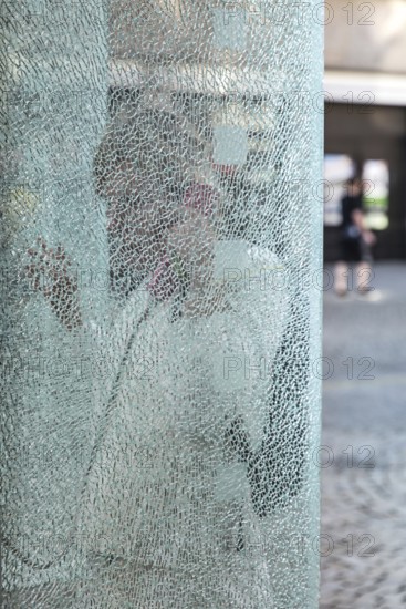 DEU Germany Germany Berlin Woman talking on the phone at a phone box with shattered glass in