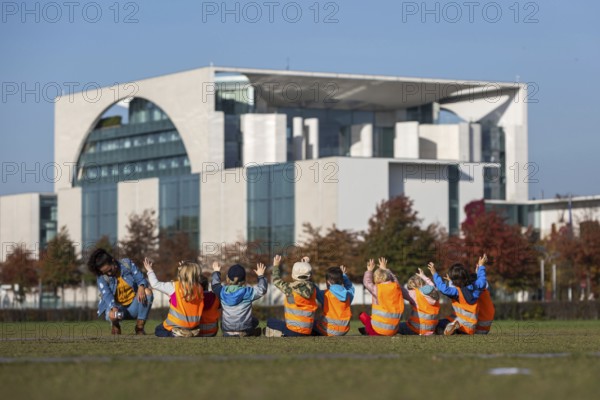 DEU Germany Germany Berlin Kindergarten children raise their hands for a group photo in front of
