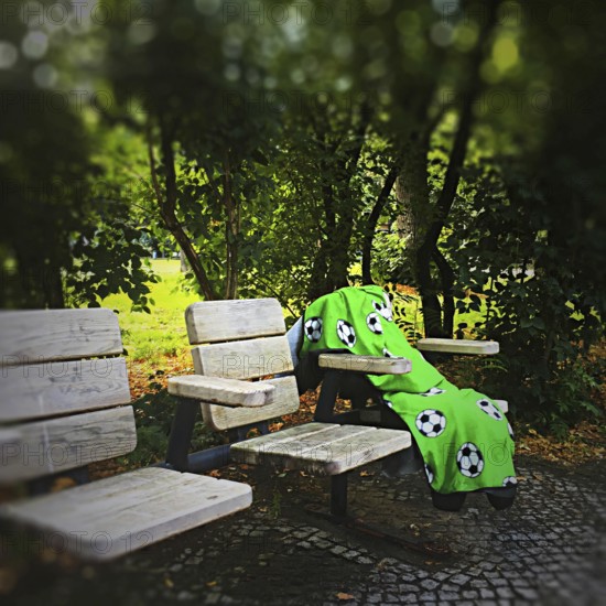 DEU Germany Germany Berlin A lonely blanket with football motifs lies abandoned on seats in a park