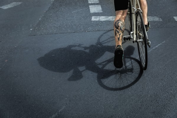 DEU Germany Germany Berlin A huge tattoo adorns the calf of a cyclist just starting out on