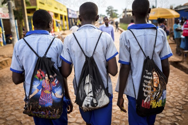 RWA RWANDA Rwanda Kayonza students in uniform carry backpacks with their idols Lionel Messi and Bob