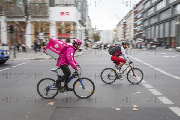 DEU Germany Germany Berlin A bicycle courier from Foodora starts off together with a cyclist at a
