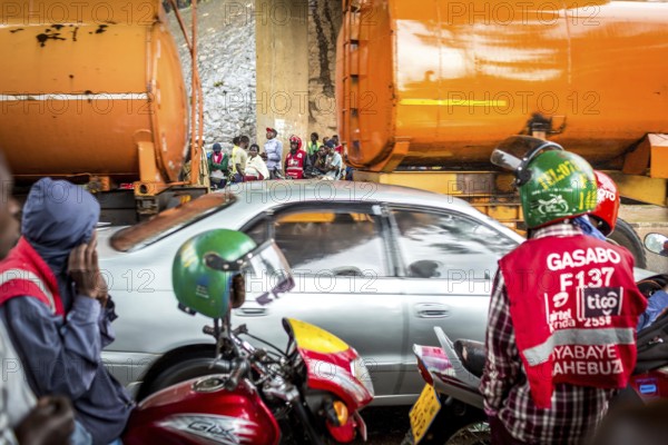 RWA RWANDA RUANDA Kigali Taxi drivers with motorbikes and bicycles wait under a bridge for the end