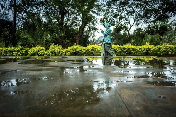 RWA RWANDA RUANDA Kigali A visitor plays in the puddles of water on a mass grave at the genocide
