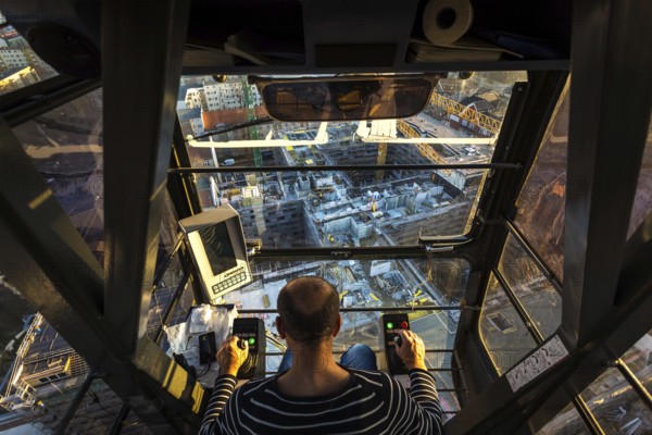 DEU Germany Germany Berlin A crane operator is transporting building materials on a construction