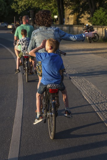 DEU Germany Germany Berlin Parents with their children on the pannier rack during a bike tour