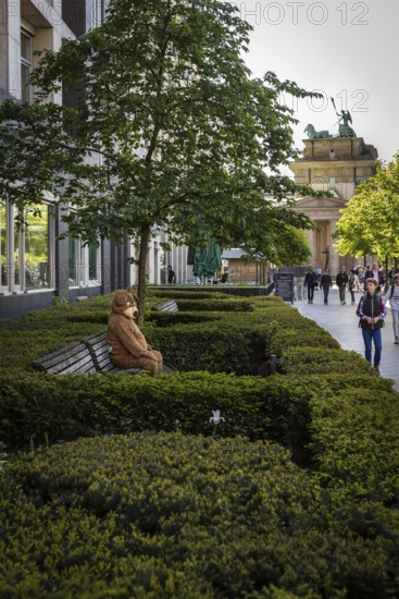 DEU Germany Germany Berlin A man in a bear costume waits on a bench for the attention of passing