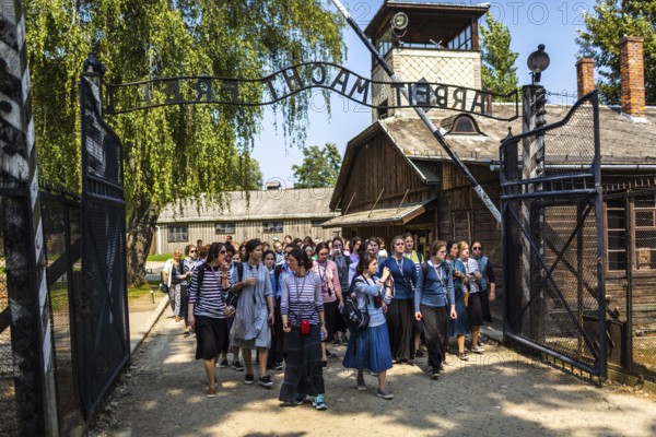 POL Poland Poland Auschwitz group of visitors at the entrance to the memorial site of the former