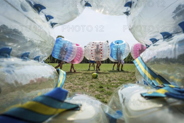DEU Germany Germany Berlin A group of Dutch tourists playing bubblesoccer in a meadow in Volkspark