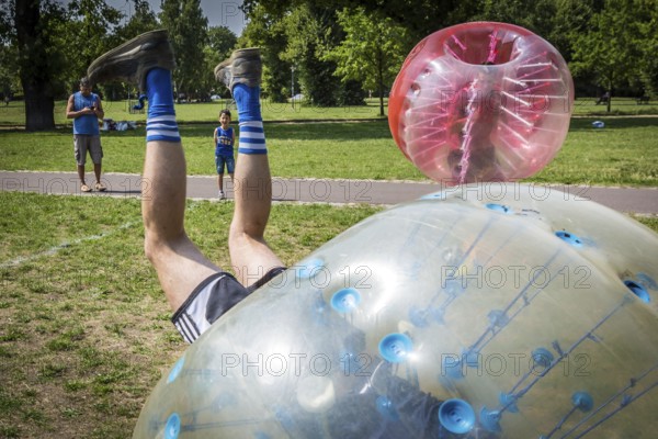 DEU Germany Germany Berlin A group of Dutch tourists playing bubblesoccer in a meadow in Volkspark