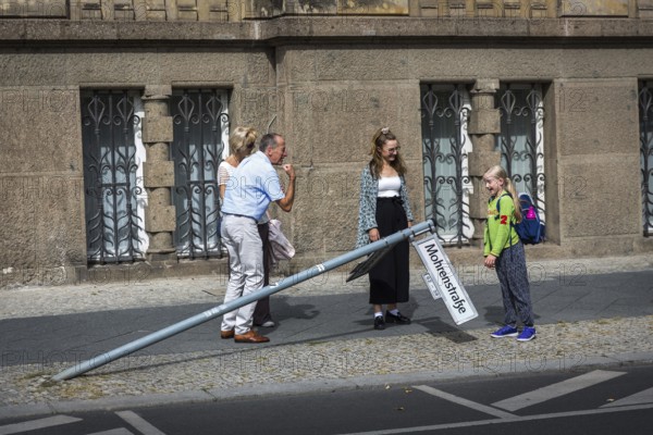 DEU Germany Germany Berlin A man shows a strong arm while a schoolgirl looks at a knocked down