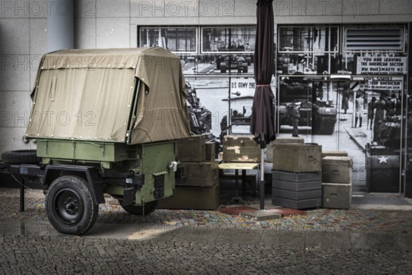 DEU Germany Germany Berlin Ammunition boxes and a military trailer in front of a photo from the