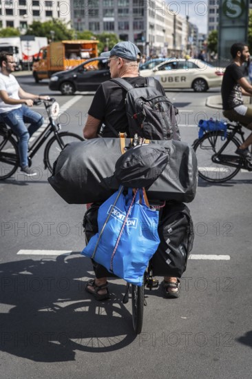 DEU Germany Germany Berlin Cyclist with numerous pieces of luggage on his bike passes Potsdamer