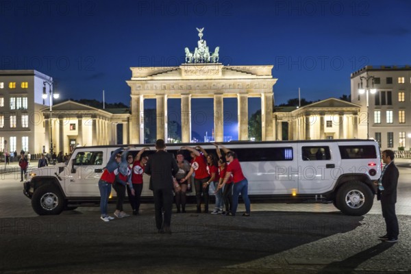DEU Germany Germany Berlin Bride with friends posing in front of stretch limousine in front of the