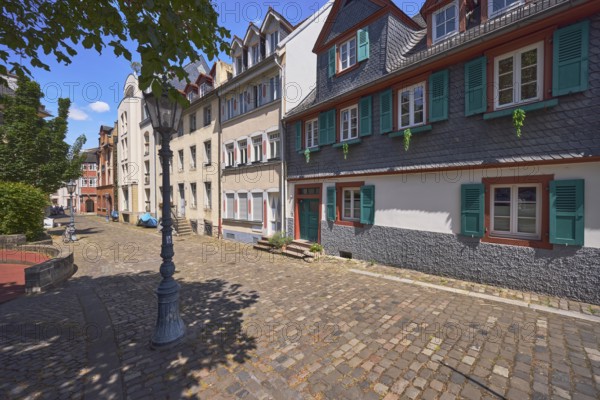 Historic building, houses, dormers, façade with windows, stairs and door, paving stone walkway,