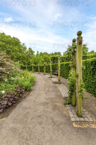 Elegant garden architecture: weathered wooden posts and chains bordering the walking trail at Hyde
