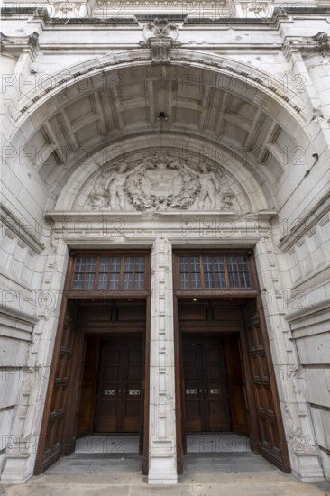 London, United Kingdom - 15 May 2025: Massive carved wooden doors beneath the highly ornate arch of