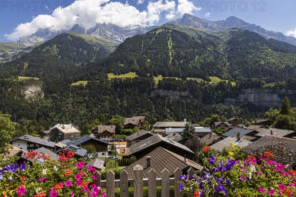 Postcard view of some mountains in Champery with flowers and chalets, in Switzerland